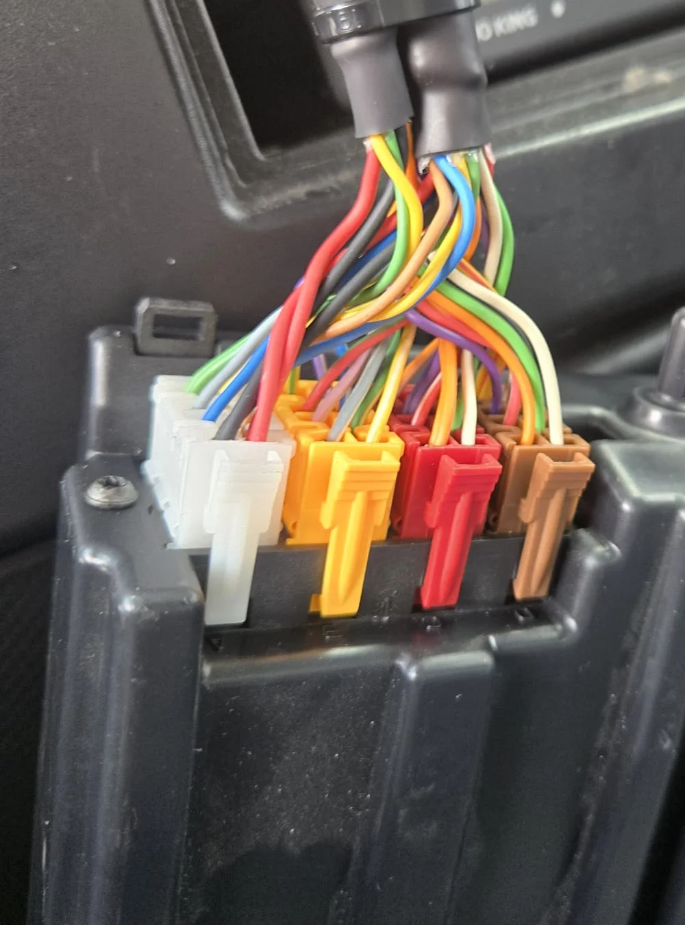 Close-up of a remote tachograph download device connected to a digital tachograph unit, showing the hardware connection process